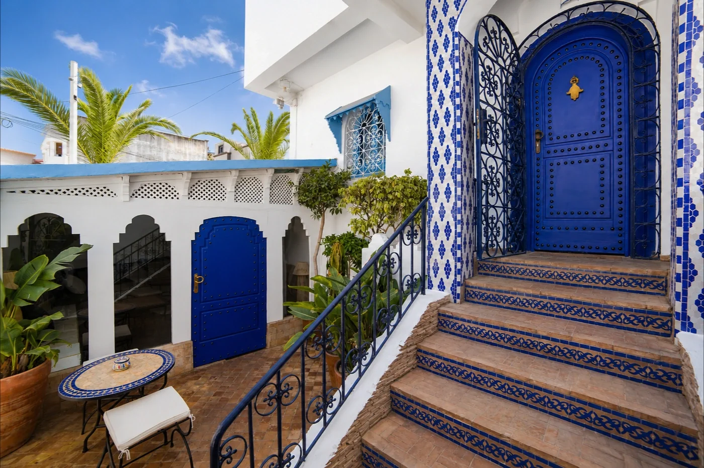 Blue entrance door and tiled staircase