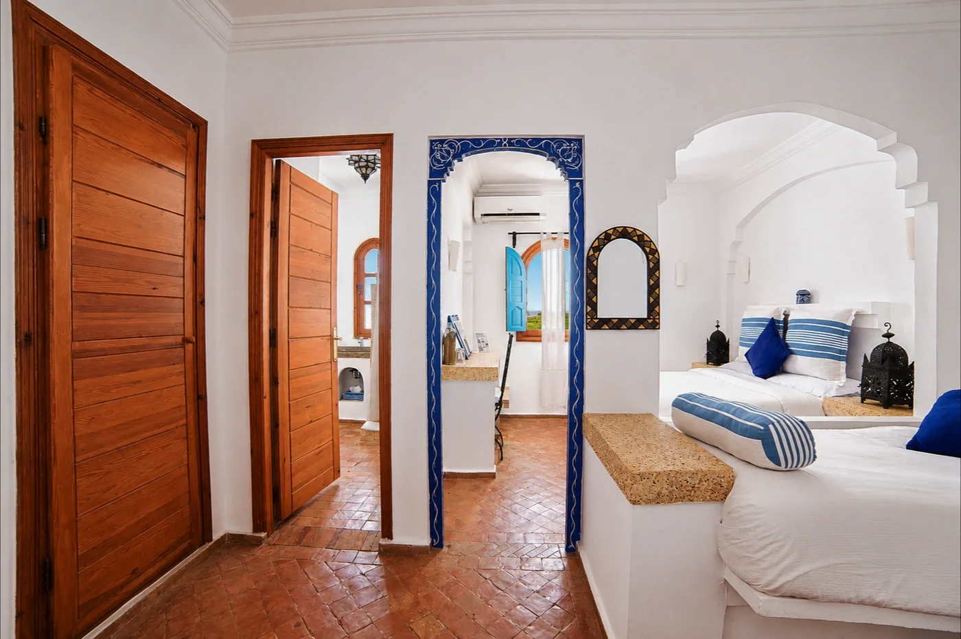Hallway with wooden doors and a blue tiled arch