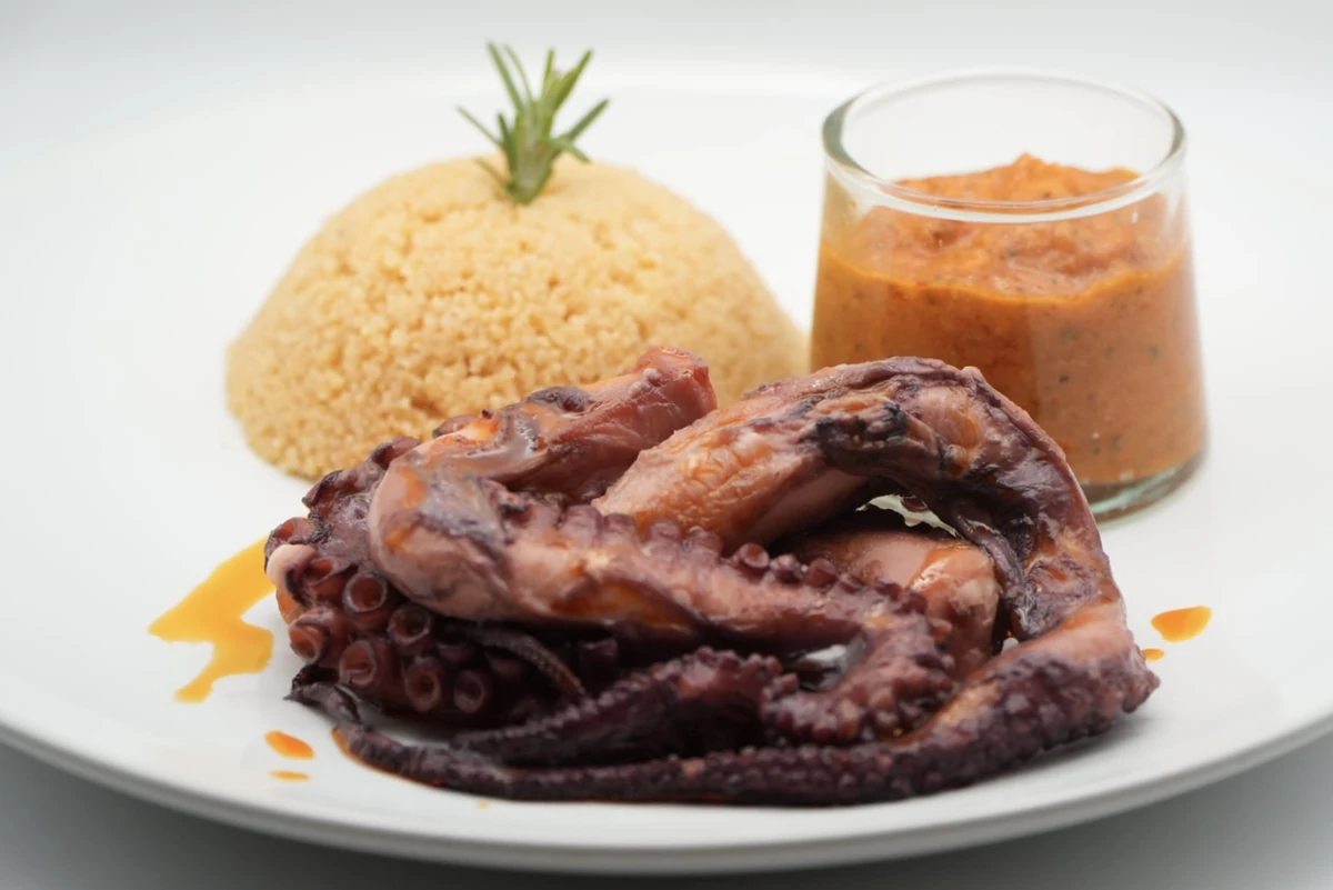Octopus, romesco sauce and flavored semolina
